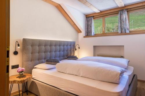 a bedroom with a large bed with a large headboard at Häuslerhof App Tilia in Villabassa