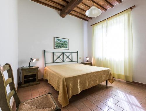 a bedroom with a bed and a large window at Podere Simonetta - A1 in Cecina