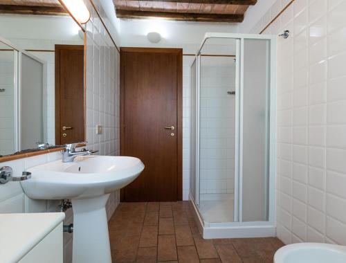 a bathroom with a sink and a glass shower at Podere Simonetta - A1 in Cecina