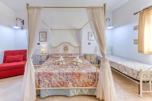 a bedroom with a bed and a red chair at Le Colonie - Pescoluse in Presicce