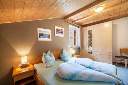 a bedroom with a bed with blue pillows at Lingerhof Arnika in Meltina