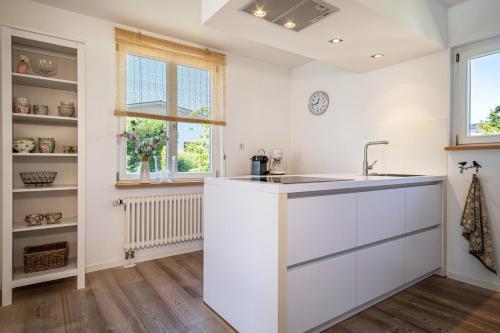 a kitchen with white cabinets and a sink at Ferienhaus Immenstaad in Immenstaad am Bodensee