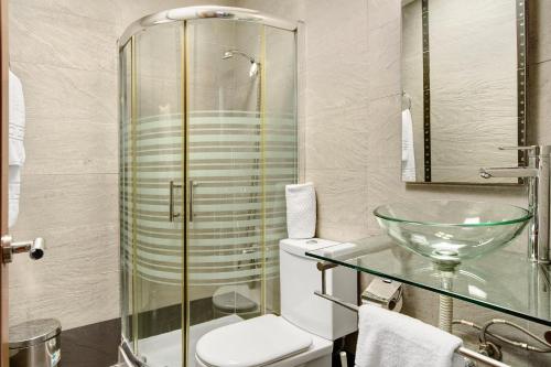 a bathroom with a toilet and a glass shower at Playmar6970 in Maspalomas