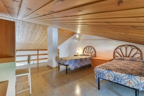 a bedroom with two beds and a table in a room at Il Quadrifoglio 2 in Procchio