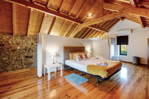 a bedroom with a bed and a stone wall at Casa de Campo com Olhar a Montanha in Sever do Vouga