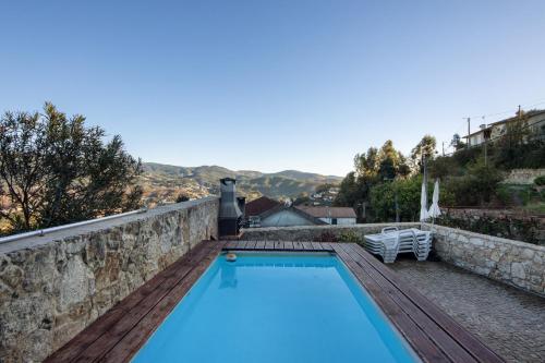 a swimming pool on top of a stone wall at Casa de Campo com Olhar a Montanha in Sever do Vouga