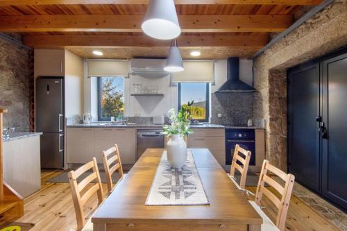 a kitchen with a long wooden table and chairs at Casa de Campo com Olhar a Montanha in Sever do Vouga