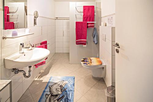 a white bathroom with a sink and a toilet at Haus Ruther - Apartment in Bad Saulgau