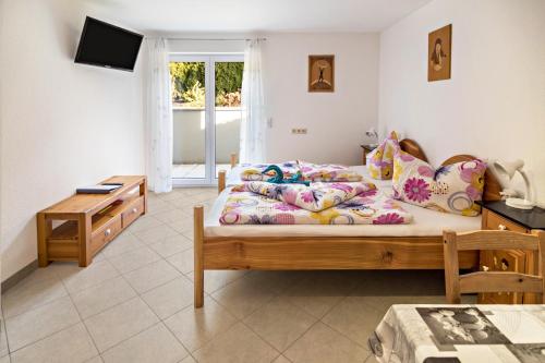 a bedroom with a bed and a desk and a television at Haus Ruther - Apartment in Bad Saulgau