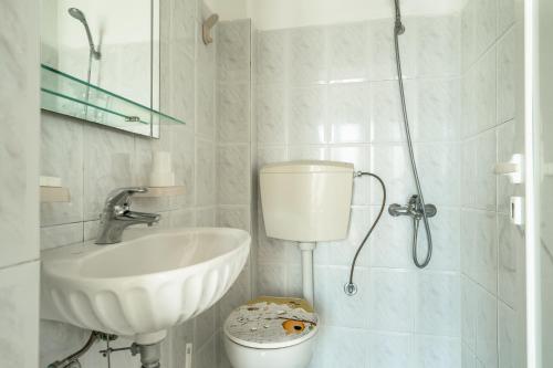 a white bathroom with a sink and a toilet at Angela sea view 7 in Kefallonia