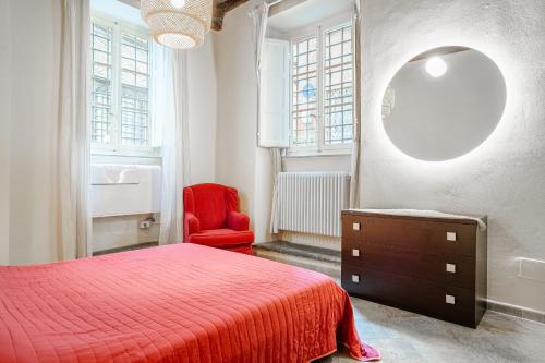 a bedroom with a red bed and a red chair at Appartamento La Naiade, Lucca in Lucca