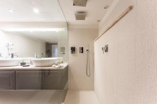 a bathroom with two sinks and a glass shower at Villa Rokkaria in Villasimius