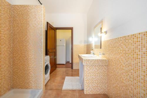 a bathroom with a sink and a washing machine at Gaia Casa Vacanze in San Giovanni Suergiu