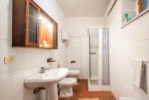 a white bathroom with a sink and a toilet at Podere del Pereto Bio- 203 in Rapolano Terme