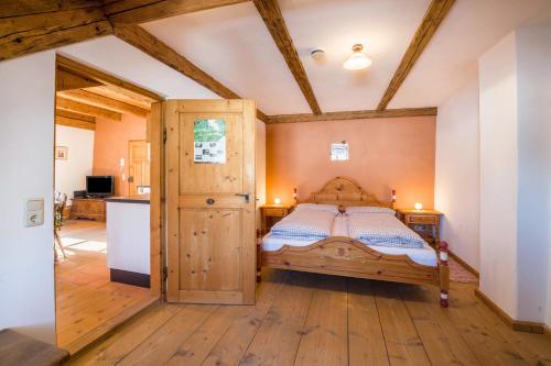 a bedroom with a bed and a kitchen at Ferienwohnung Gschwand in Unterammergau