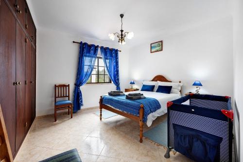 a bedroom with a bed and a chair and a window at Casa Brita in Raposeira
