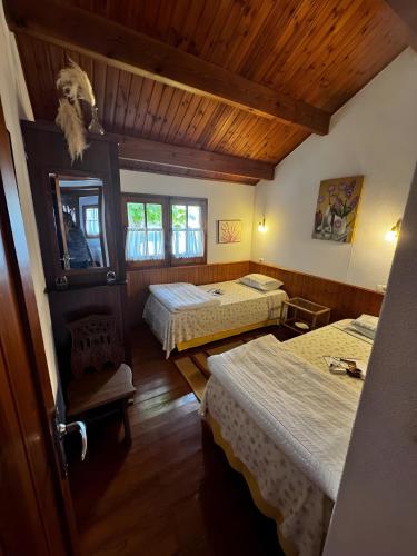 a bedroom with two beds and a wooden ceiling at Shakti Rio Mino in San Bartolomé