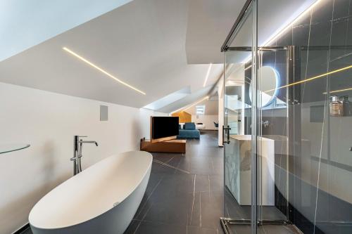 a bathroom with a white tub and a glass wall at App 304 Palazzo Cavour in Bolzano