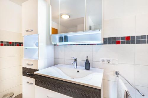 a white bathroom with a sink and a mirror at Am Döttelbach in Bad Peterstal-Griesbach