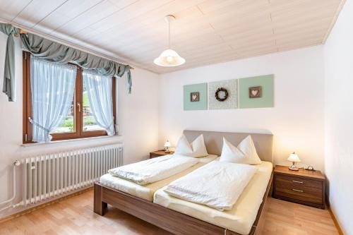 a bedroom with a bed and a window at Am Döttelbach in Bad Peterstal-Griesbach