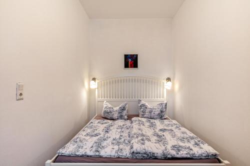 a small bedroom with a bed with blue and white sheets at Im Herzen Templins Obergeschoss in Templin
