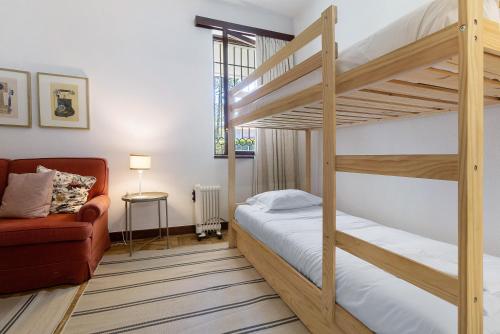 a bedroom with two bunk beds and a couch at Casa de Santo António Moledo in Moledo