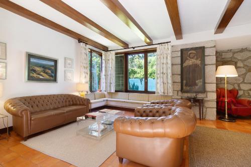 a living room with a leather couch and a table at Casa de Santo António Moledo in Moledo