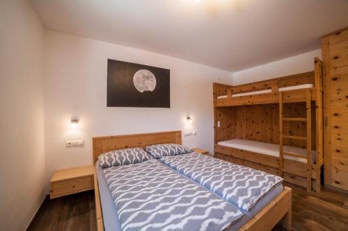 a bedroom with a bed and two bunk beds at Ferienwohnung Haus Fliri in Curon Venosta