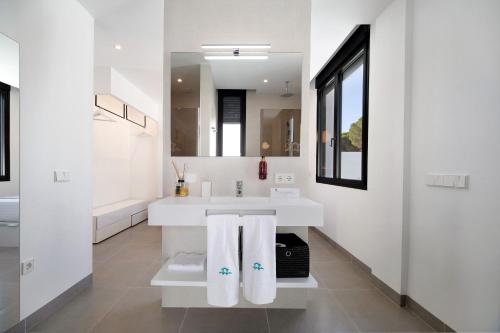 a white bathroom with a sink and a mirror at Andrea Sea Villa in Novo Sancti Petri