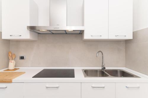 a kitchen with white cabinets and a sink at San Teodoro Villa Nina Costa Caddu in San Teodoro