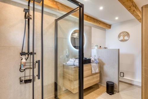 a shower with a glass door in a bathroom at Le Mas de Coeur in Bédarieux