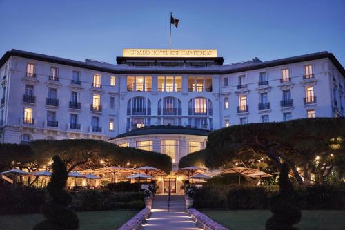 een groot wit gebouw met een vlag erop bij Grand-Hôtel du Cap-Ferrat, A Four Seasons Hotel in Saint-Jean-Cap-Ferrat