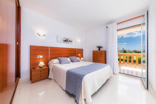 a bedroom with a bed and a large window at Apartamento Serendipia in Cala Bona