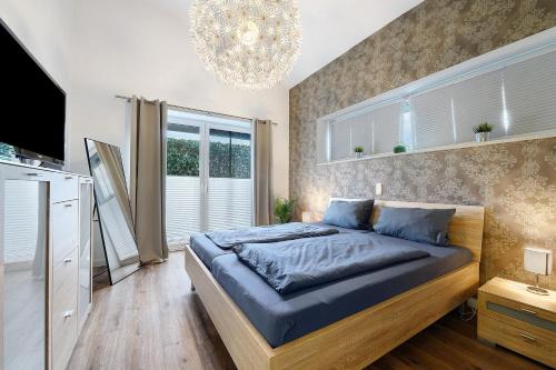a bedroom with a bed and a chandelier at Idylisches Ferienhaus in Edewecht