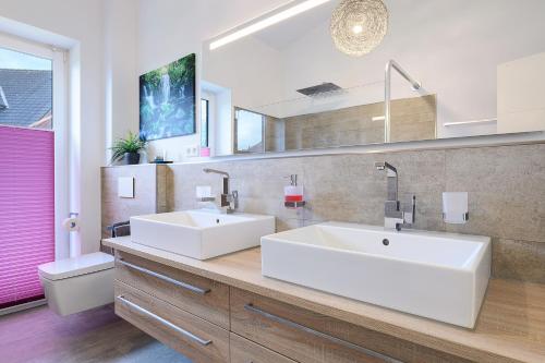 a bathroom with two sinks and a large mirror at Idylisches Ferienhaus in Edewecht