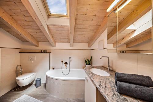 a bathroom with a tub and a toilet and a sink at Panoramawohnung Annaheim in Rifiano