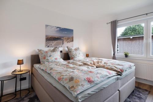 a bedroom with a large bed with a floral bedspread at Ferienhaus Anna Elbe in Wischhafen