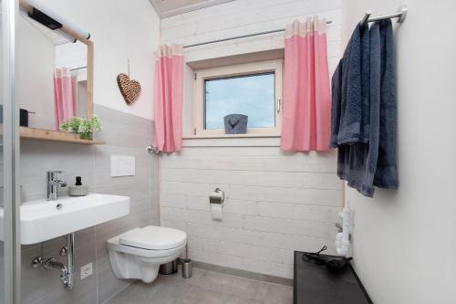 a bathroom with a toilet and a sink and a window at Ferienwohnung Junge in Halblech