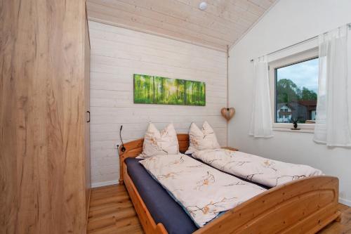 a bed with pillows on it in a room with a window at Ferienwohnung Junge in Halblech