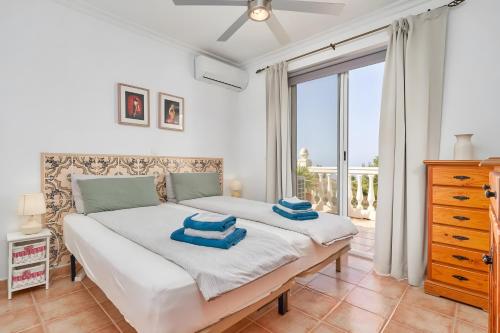 a bedroom with a bed with blue towels on it at Villa Estrella de Cotobro in Almuñécar