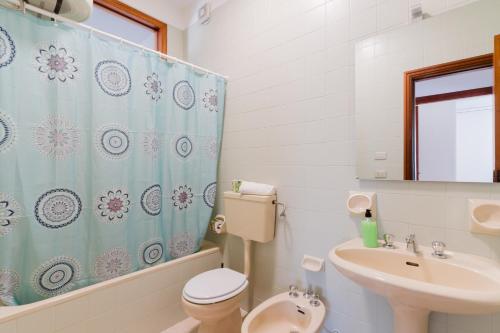 a bathroom with a sink and a toilet and a shower curtain at Casa Giselle a Otranto in Otranto