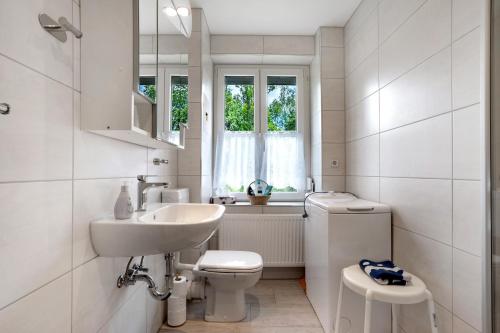 a white bathroom with a sink and a toilet at Gästewohnung am Schwanenteich in Mittweida