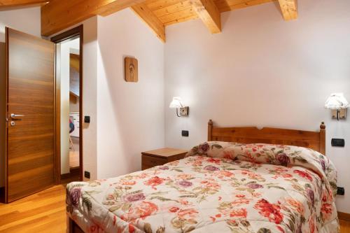 a bedroom with a bed with a floral bedspread at Residence Chalet Provenzale in Acceglio