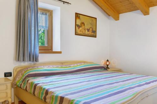 a bedroom with a bed with a colorful striped blanket at Chalet Camillo in Moline
