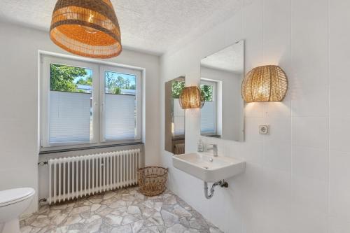 a bathroom with a sink and a toilet and windows at db Staycation Ferienpark in Niedenstein