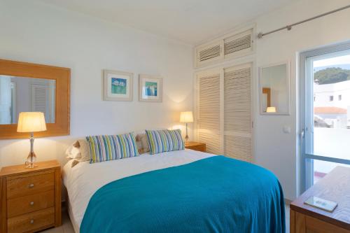 a bedroom with a bed with a blue blanket at Vila Senna in Vale do Lobo