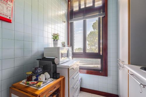a kitchen with a microwave on top of a counter at Sunset Troia Beach in Troia