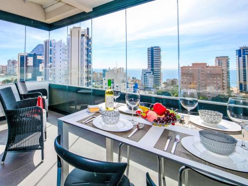 a table with wine glasses and a bowl of fruit on a balcony at Apartment Alexia by Interhome in Ifach