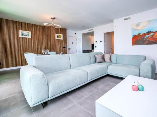 a living room with a blue couch and a table at Apartment Alexia by Interhome in Ifach