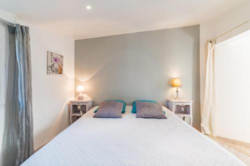 a bedroom with a large white bed with two pillows at La Miellerie in Gréoux-les-Bains